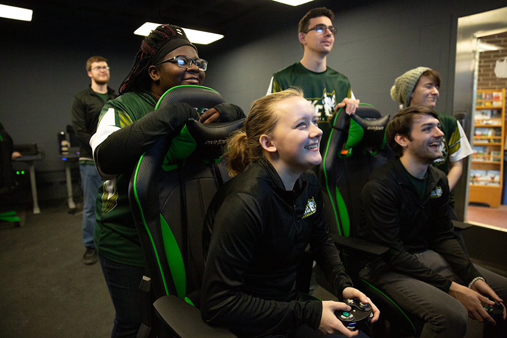 esports arena - students gathered around a computer watching their teammate game