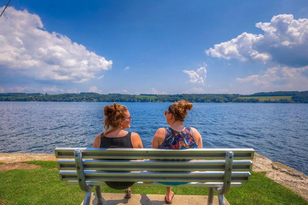 Students sit and look out at Keuka Lake from the Strong Apartment complex