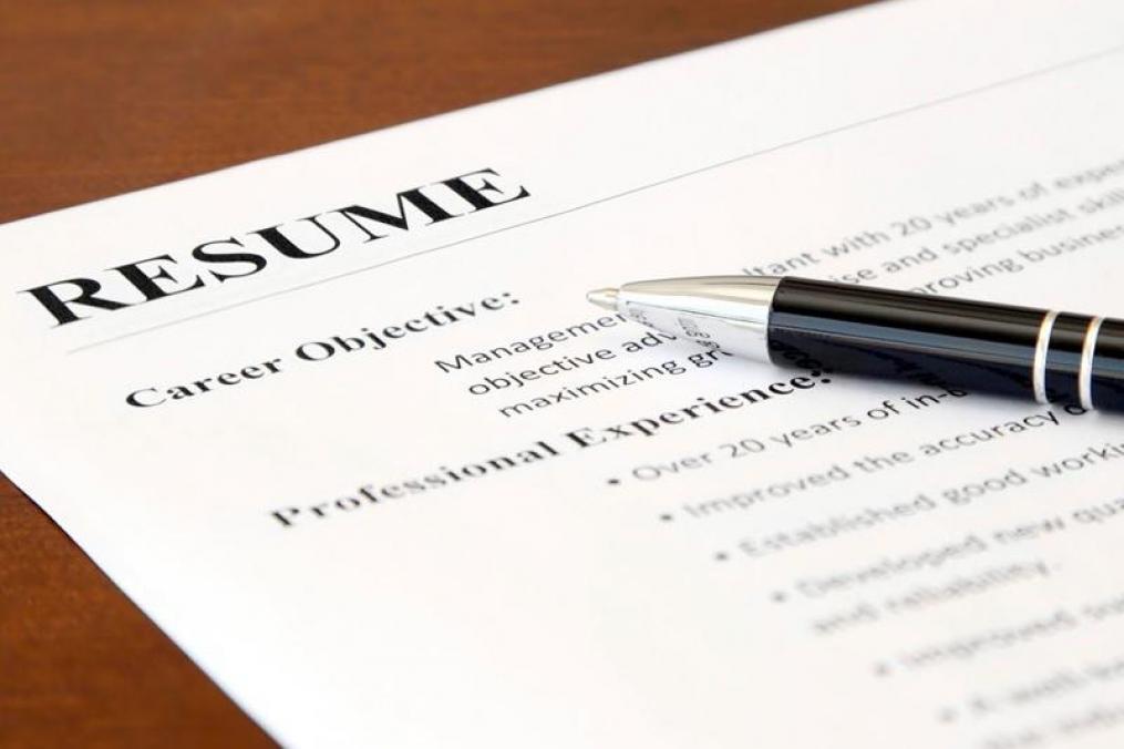resume on a desk with a pen sitting on top of it