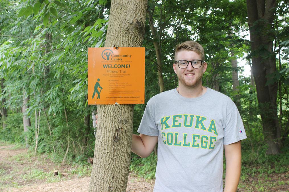 Senior Dan Lazzaro stands next to a sign marking