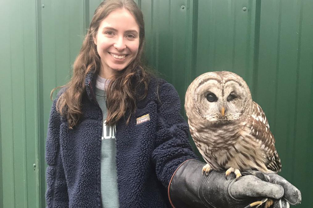 sophomore Grace DelRossa posing for a photo with an owl sitting on her left hand