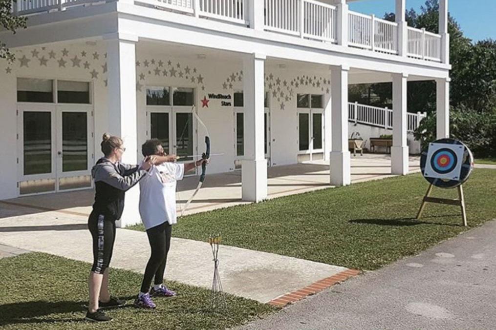 Meg Calhoun '18 helps one of her students practice archery.