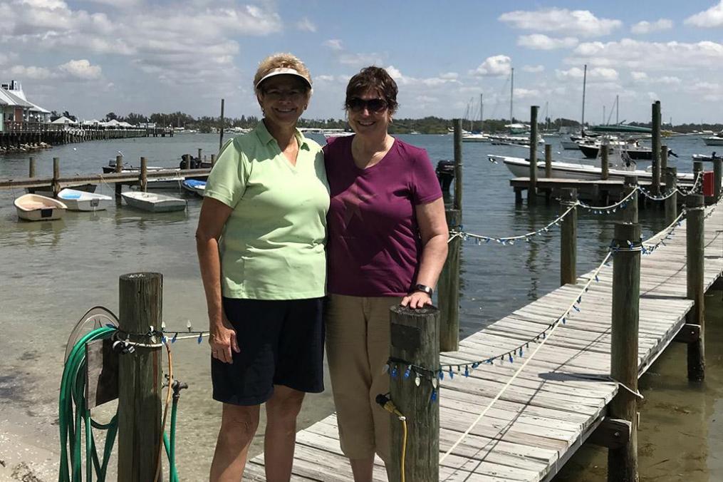 Libby Stearns Faison standing on a dock next to her sister Dr. Jan “Nursie” Stearns Wyatt