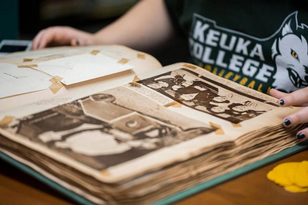 A student reads through a Keuka College history book