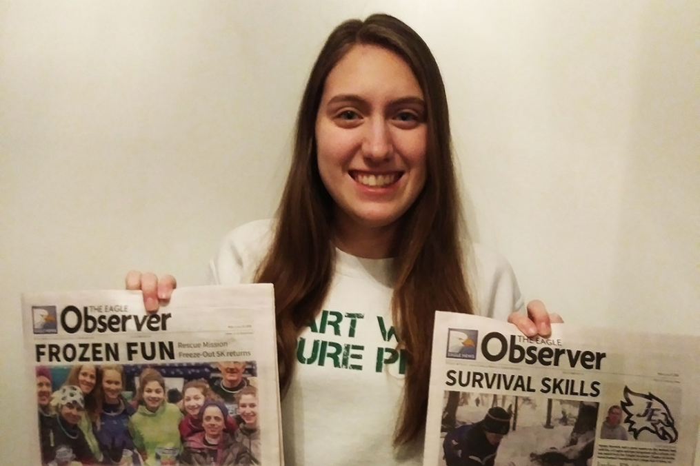 Christina Young holding two newspapers up showing off her headlines