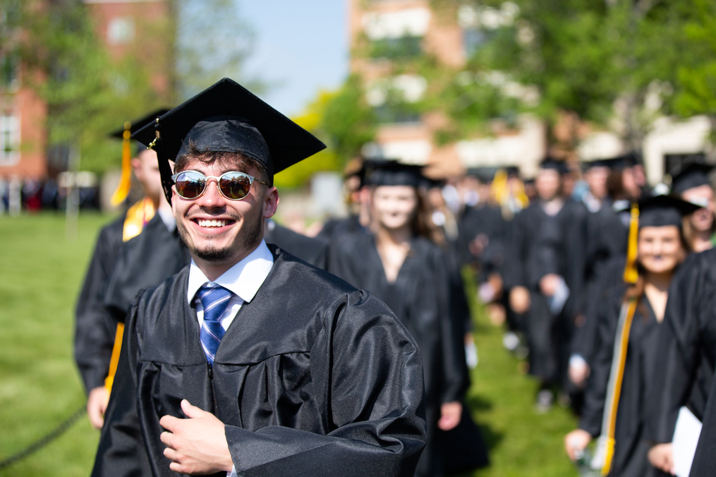 Students walking in commencement regalia toward the ceremony