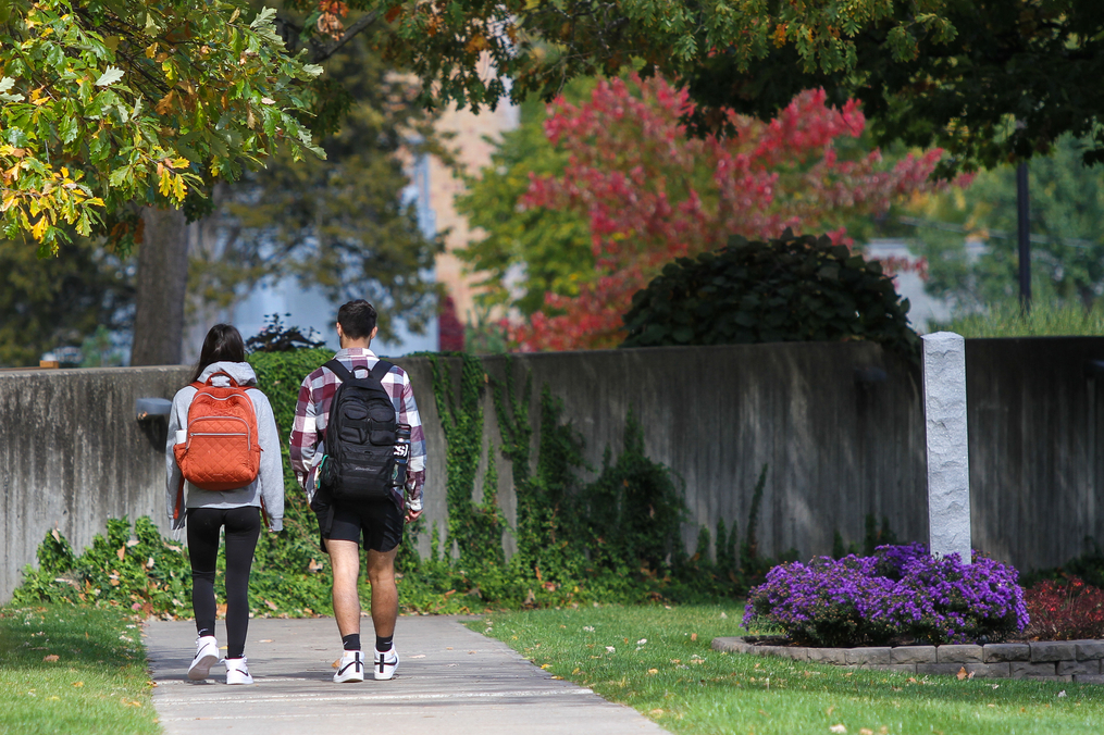 Two students walking toward Lightner Library wearing backpacks 