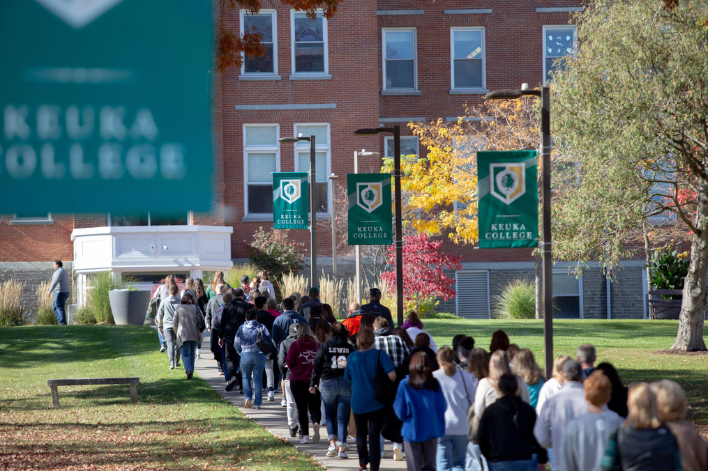 Students at a Fall Open House event walking up the sidewalk toward Ball Hall 