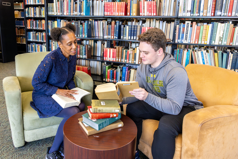 Dr. Sekai Turner works with student, James Murphy in the library