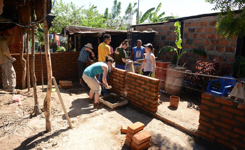 Keuka College students help lay bricks at a home.