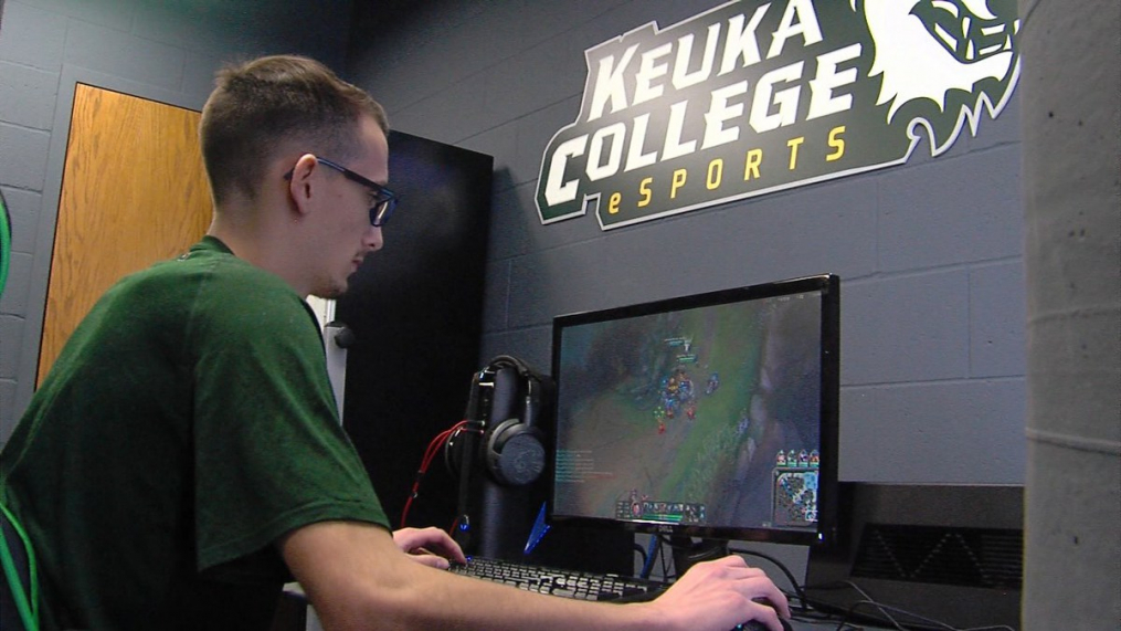 student sitting in front of a computer playing a video game