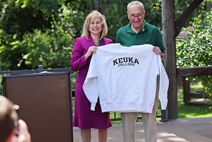 President Amy Storey with Senator Chuck Schumer holding a Keuka College sweatshirt